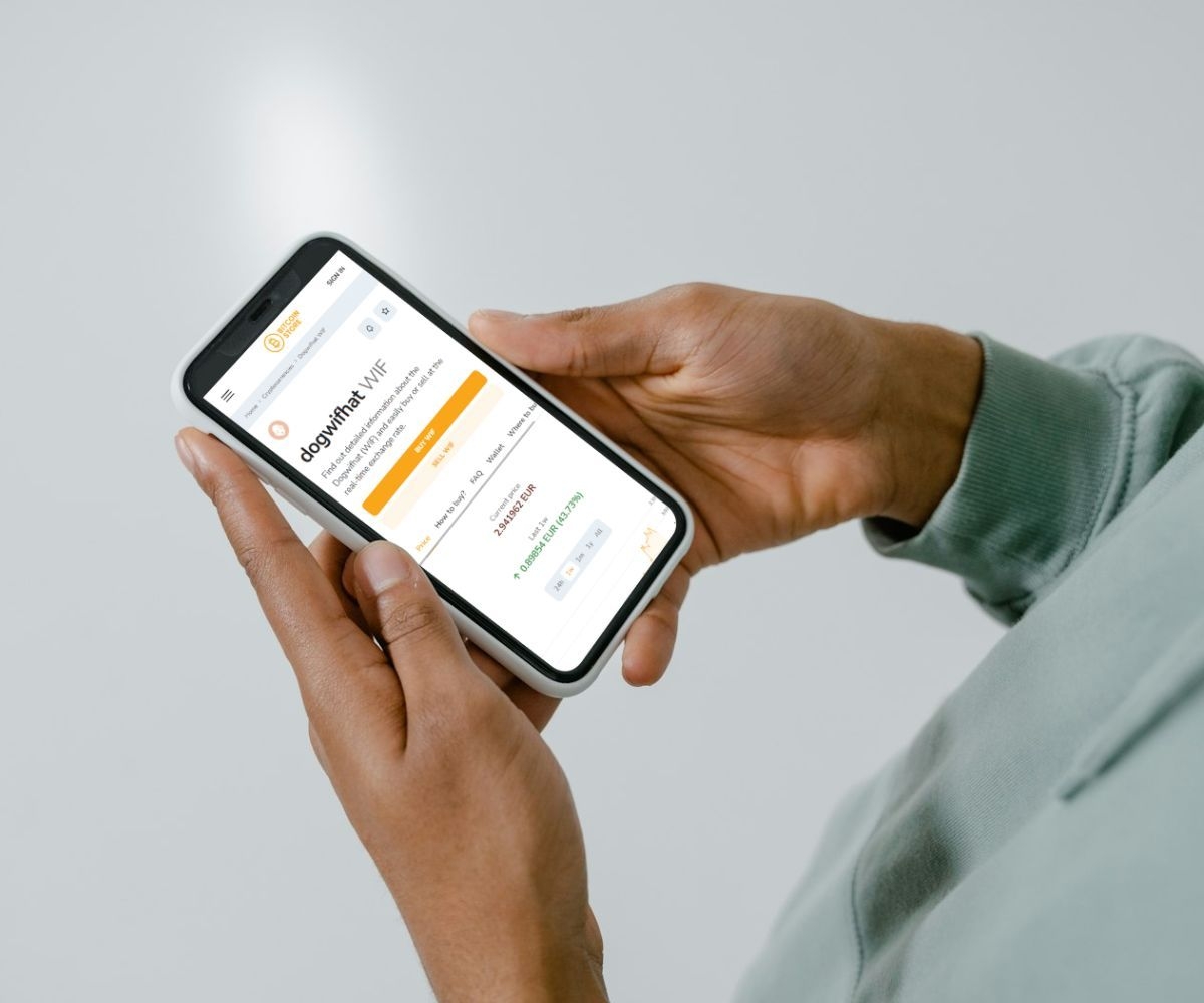 L'image montre une personne parcourant la cryptomonnaie dogwifhat (WIF) sur la version mobile de la plateforme Bitcoin Store